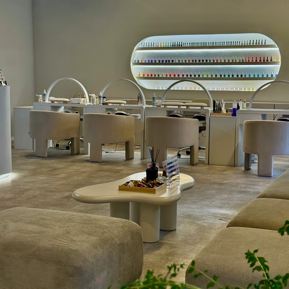 Ein moderner Nagelstudio mit stilvollen Möbeln und einer Nagellackwand.